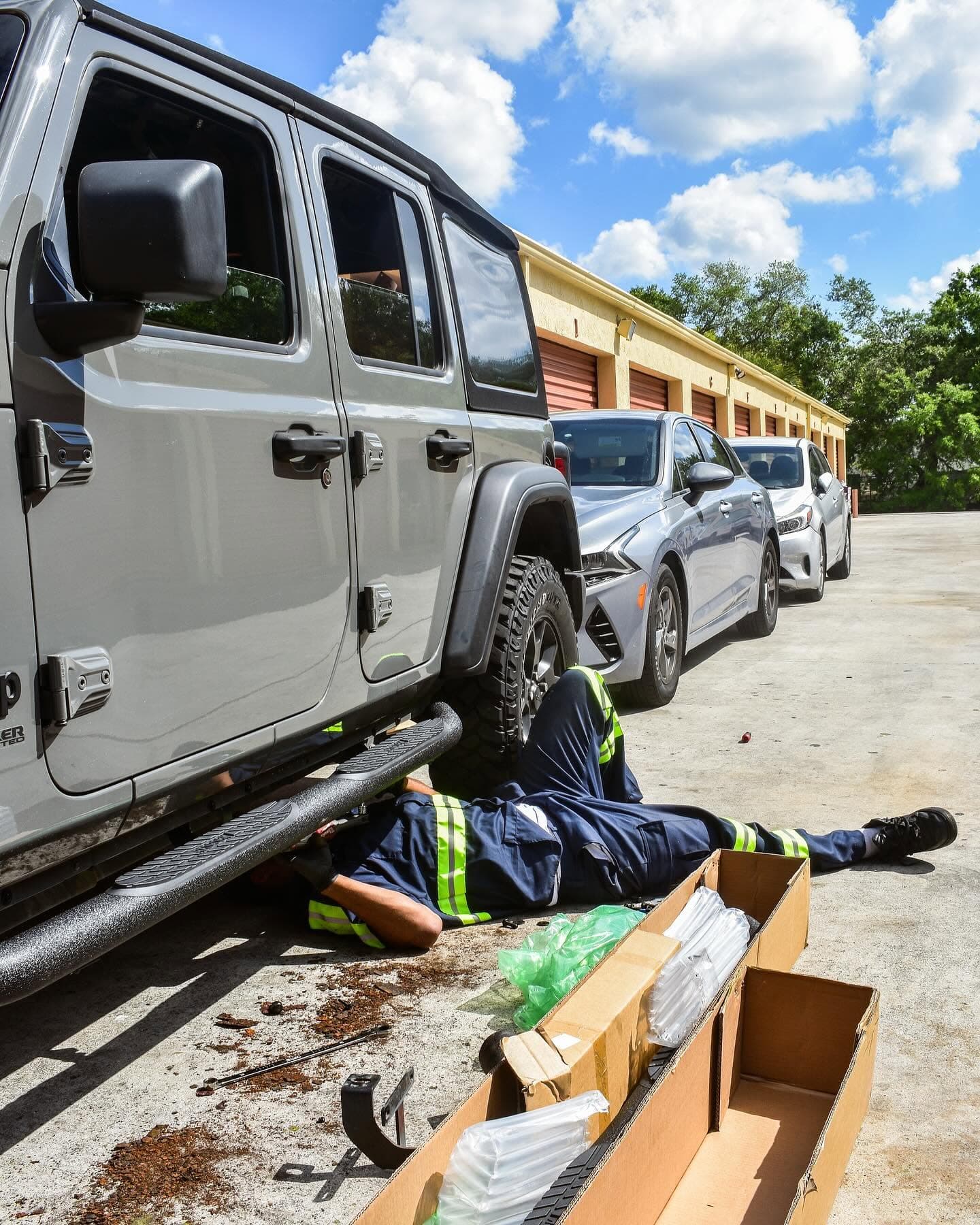 Hook & Book technician installing parts under a Jeep Wrangler