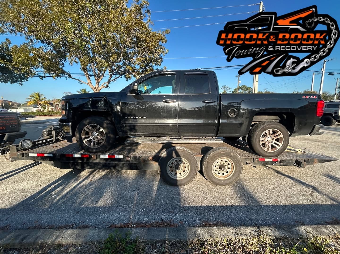 Damaged Chevrolet Silverado secured on a Hook & Book flatbed